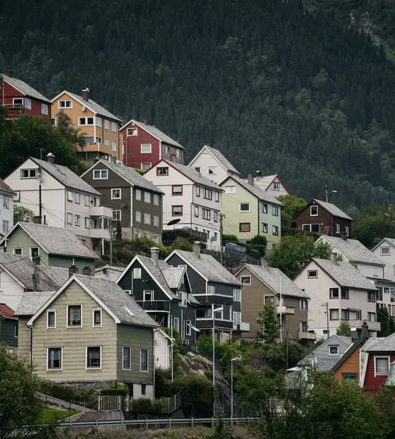 Farverige træhuse på en fjeldside i Odda, Norge